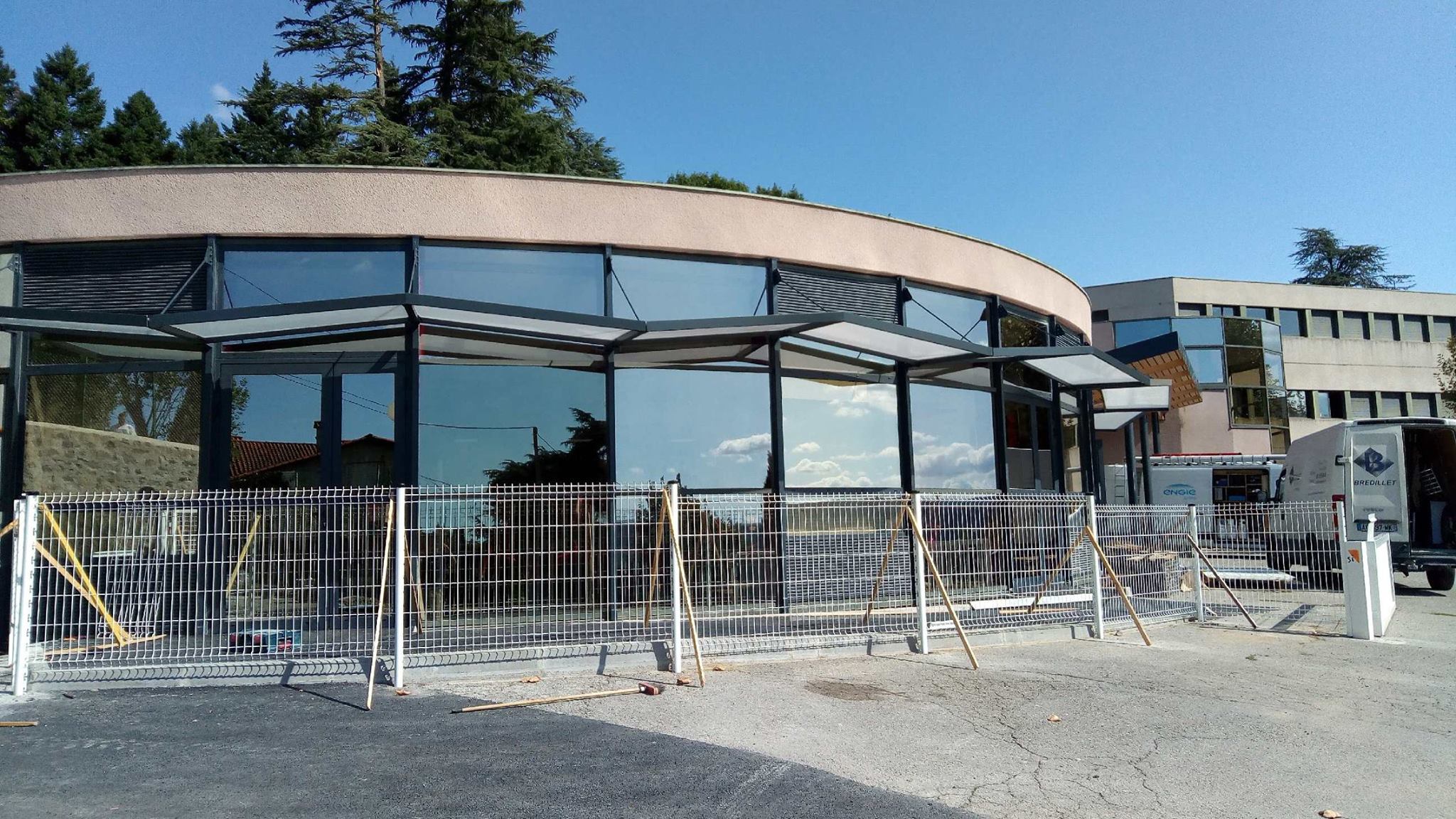 Curved glazed facade with a steel frame and steel canopies